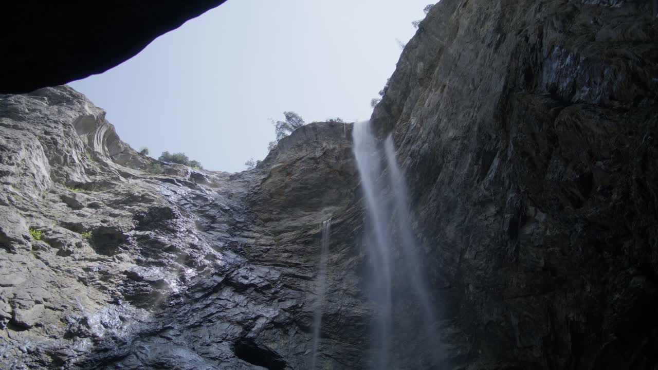 gran cascada con agua que fluye rápidamente | cueva de grindelwald suiza en el cañón del glaciar, europa, 4k