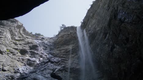 large waterfall with fast flowing water | grindelwald switzerland cave in glacier canyon, europe, 4k