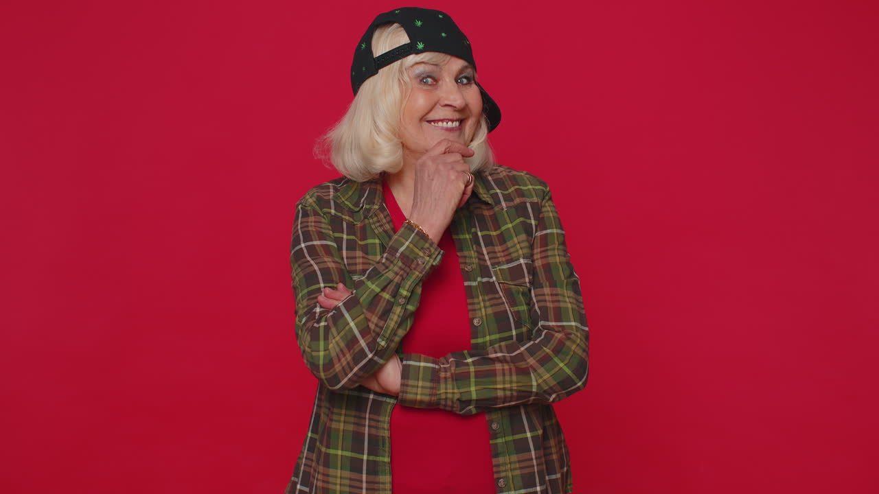 Cheerful gray-haired senior woman fashion model in casual shirt smiling and looking at camera alone