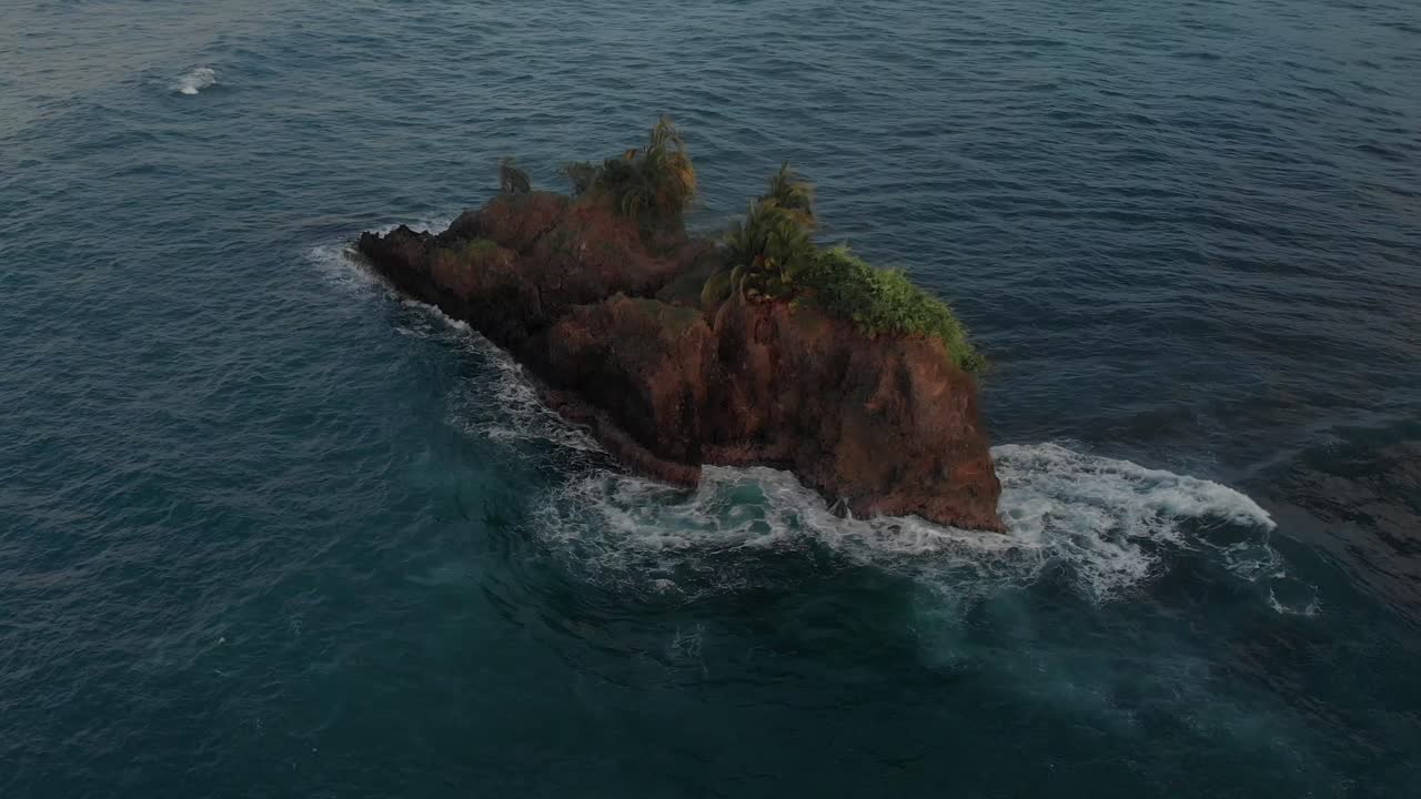 Waves Splashing On The Rocky Lost Island In The Middle Of The Ocean In Puerto Viejo, Costa Rica - Aerial Shot