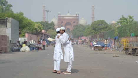 muslim men celebrating eid and exchanging gifts in front of mosque