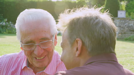 Senior-man-and-middle-aged-son-talking-in-the-garden