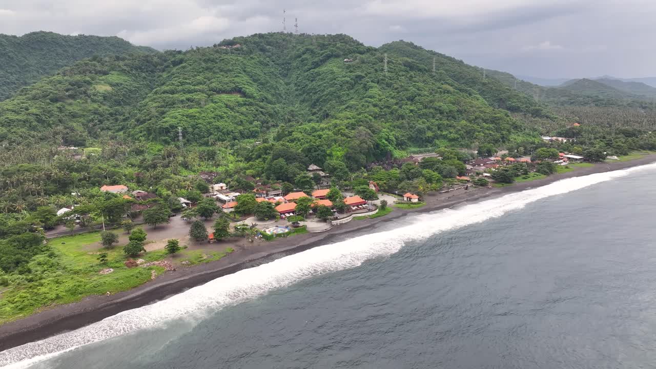 Aerial view of black sand volcanic beach at Bali Coastal, Pantai Goa Lawah. Tropical climate.