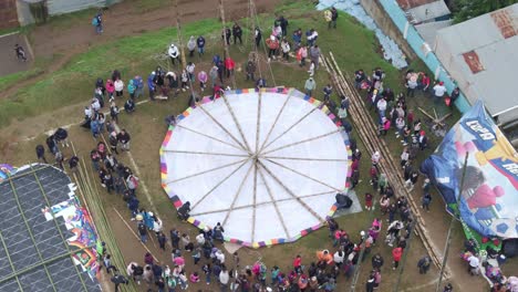 Gente-Abarrotada-Reunida-Alrededor-De-Una-Cometa-Gigante-En-Sumpango,-Aérea