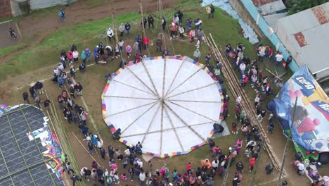 crowded people gathered around giant kite at sumpango, aerial