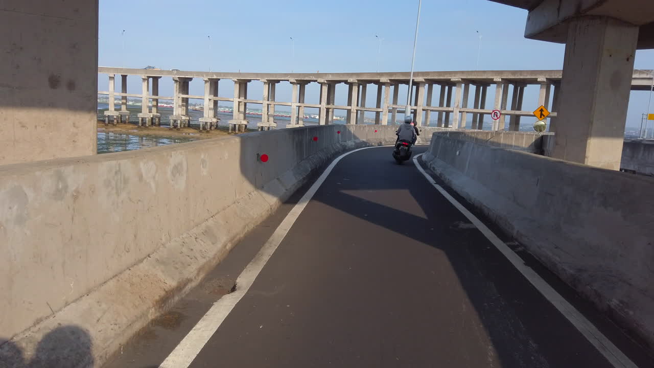 인도네시아 발리 동남아시아의 콘크리트 구조물 아래로 스쿠터 운전