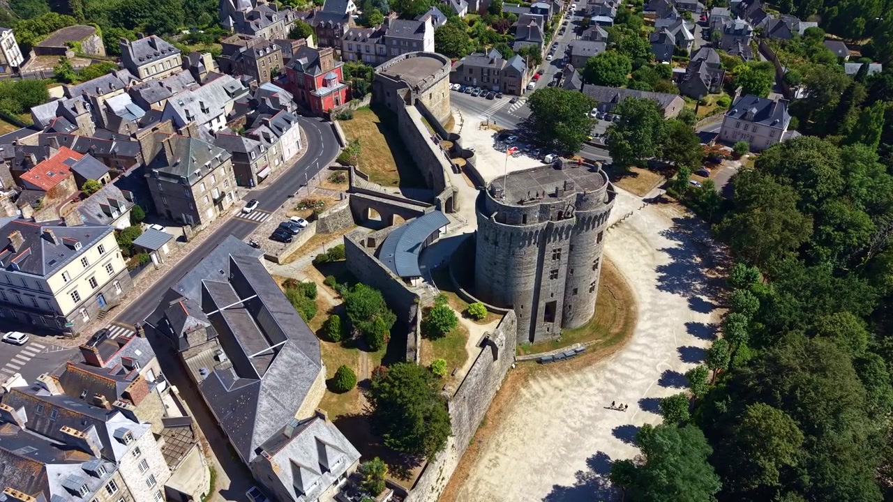 Drone terbang dan menurun menuju Château de Dinan, menampakkan benteng abad pertengahan, taman di sekitarnya, dan kota bersejarah di Brittany.
