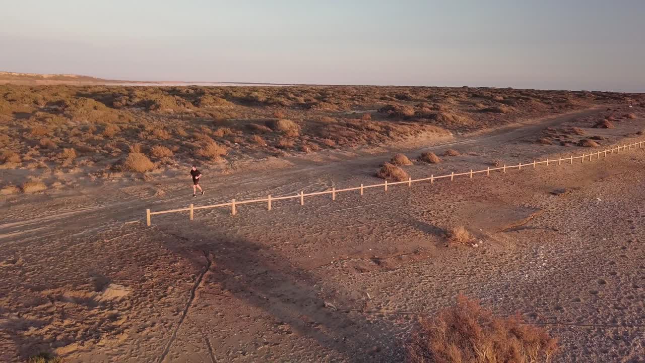 Young man running in the desert landscape