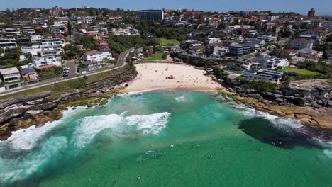 las olas salpicando en la playa de tamarama en sídney, nsw, australia - fotografía aérea de un dron