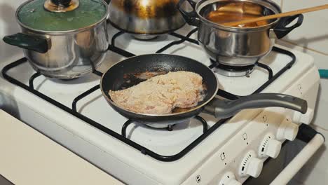 Grandma,-mother-puts-a-pork-chop-to-fry