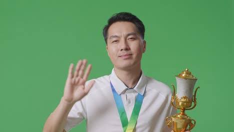 man celebrating victory with trophy and medal