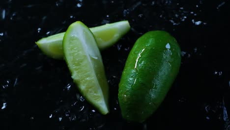 Kalk-Und-Kalkviertel-Werden-Mit-Wasser-Auf-Einer-Schwarzen-Oberfläche-Bespritzt