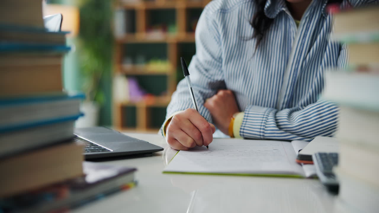 A person studying with books and a laptop
