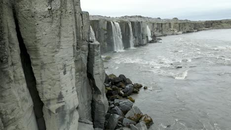 revealing droneshot of waterfalls flowing into a river