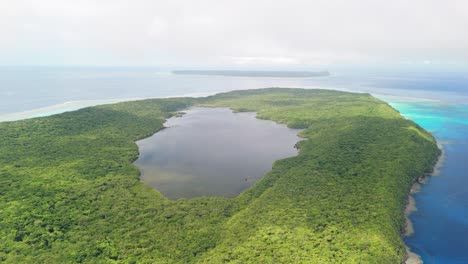 drone flying in the clouds to reveal salt water lake on top of island