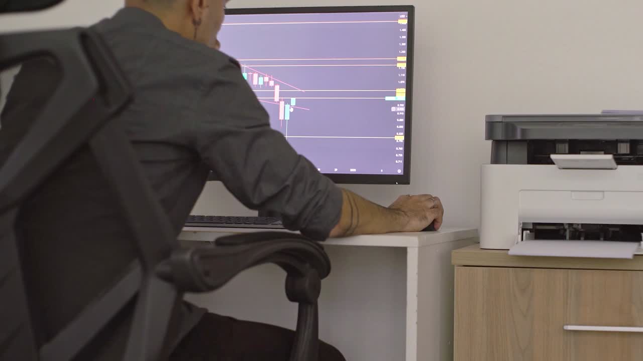 Broker esperto che analizza grafici finanziari, indicando più schermi di computer mentre monitora le tendenze di mercato e i dati di investimento in un ambiente d'ufficio professionale.