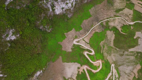 Top-down-shot-of-a-winding-road-cut-into-the-mountains-of-the-gorgeous-Ma-Pi-Leng-Pass-in-northern-Vietnam