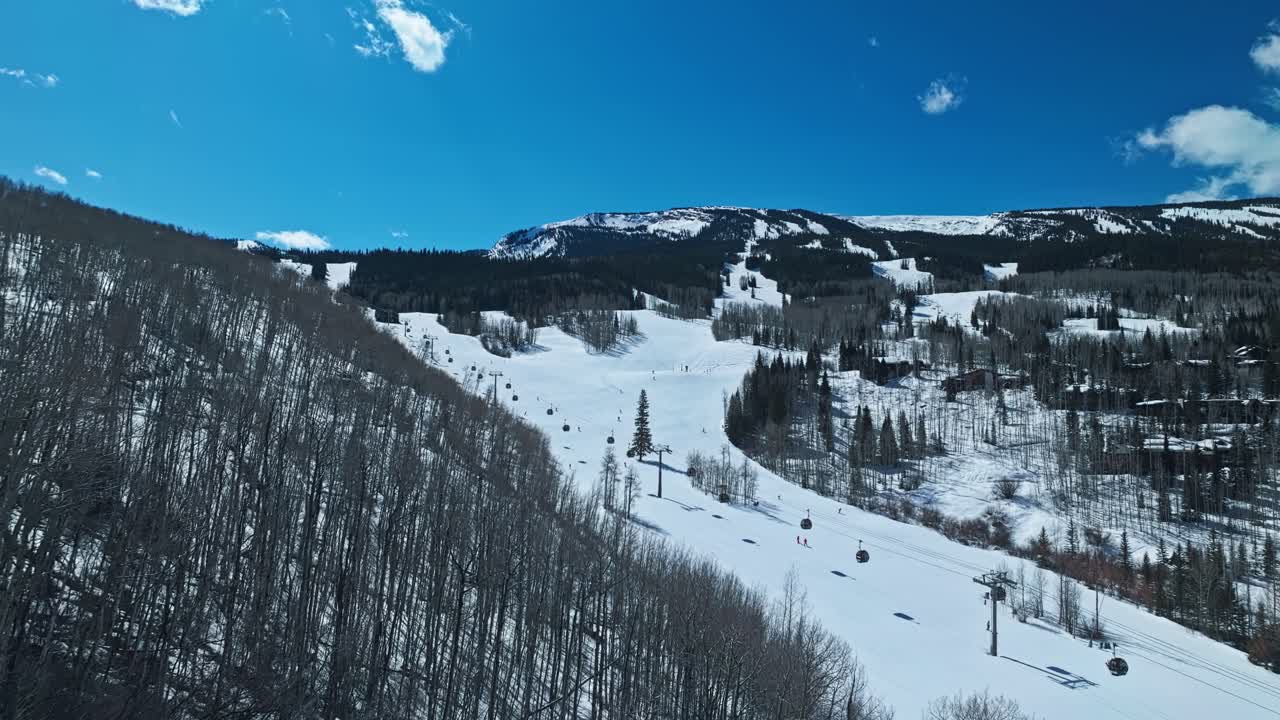 Daylight reveals ski slopes, frozen terrain, and surrounding trees in scenic alpine winter view, establishing overview, Snowmass Colorado USA