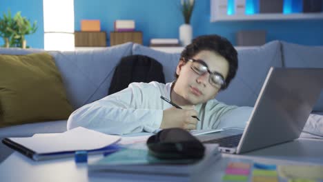 tired and sluggish male student falls asleep while studying at home.