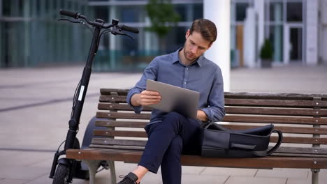 man with scooter sitting on a bench
