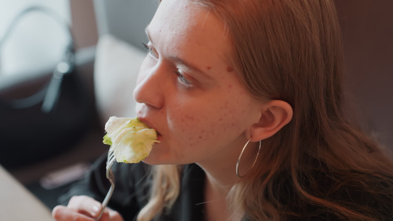 Una mujer elegante prueba con entusiasmo delicados sabores de flores pálidas. Esta dama a la moda, con pendientes de aro y bolso, examina aromas florales sutiles y refinados durante su exploración.
