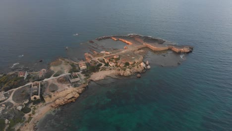 side panning shot of punta della mola ruins at sicily italy, aerial