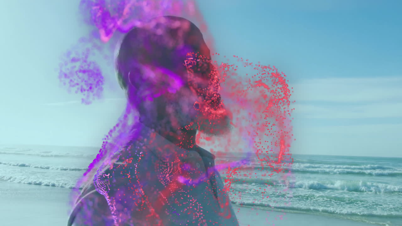man standing on beach, technology concept unfolding with swirling purple and red particle effects