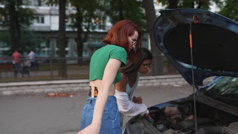 mujeres reparando un coche averiado