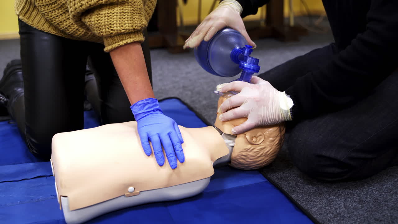 Process of cardiopulmonary resuscitation. People practicing cardiopulmonary resuscitation on mannequin at first aid class