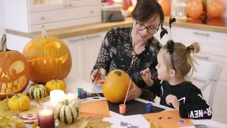 Mother-and-daughter-painting-face-on-pumpkin