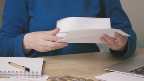 female hands opening envelope letter document or bills, reading, writing down