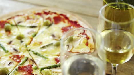 delicious pizza with a glasses of wine and wine bottle