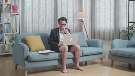 소파에서 노트북으로 일하는 남자