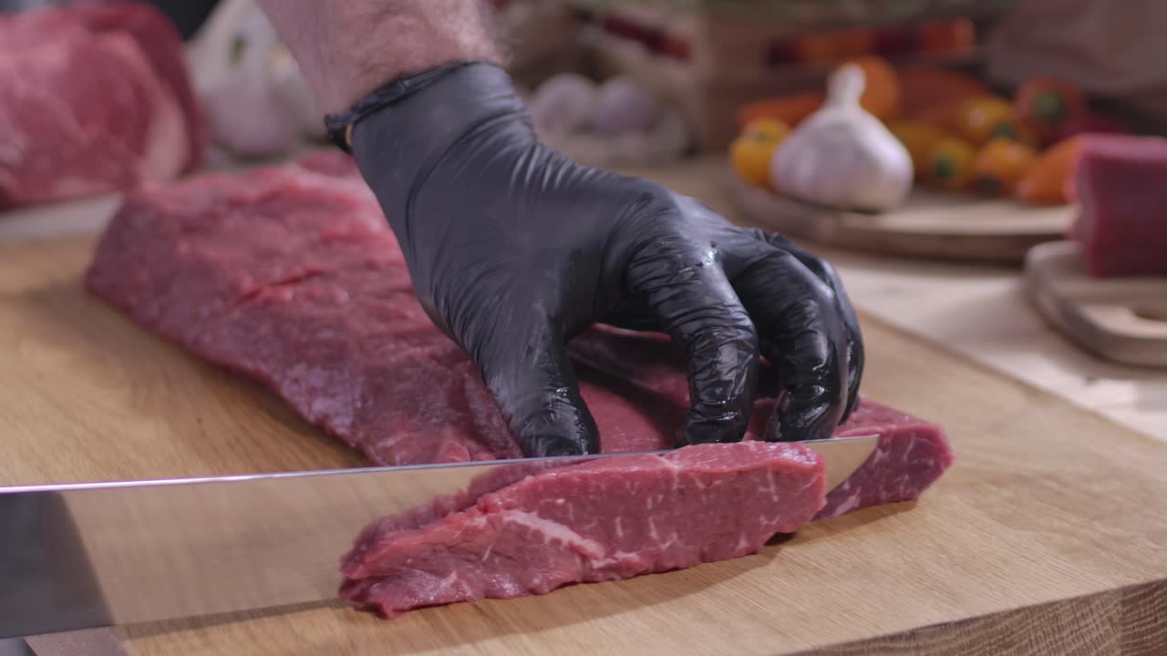 Macellaio che segue i protocolli di igiene indossando guanti neri mentre affetta con precisione delle strisce di manzo fresco