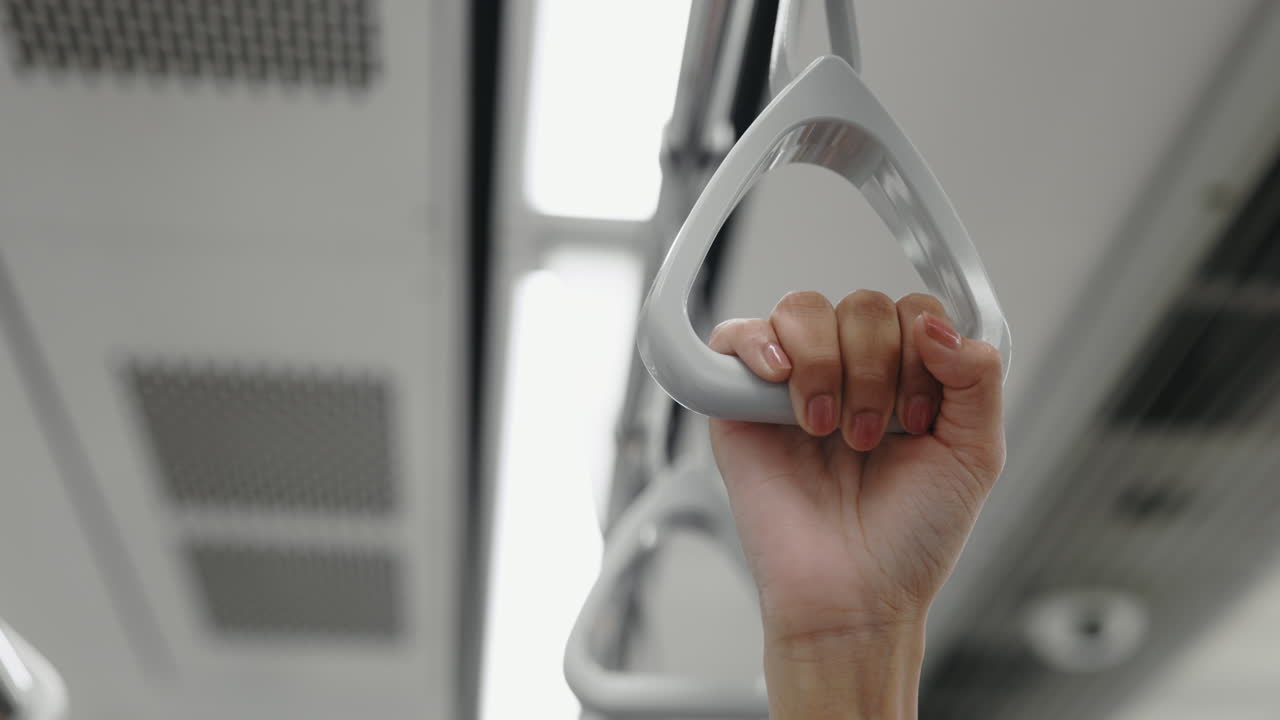 Hand holding onto a train grip