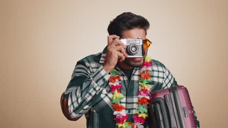 Happy-indian-man-tourist-photographer-taking-photos-on-retro-camera-and-smiling,-holiday-vacation