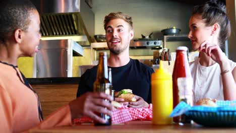 friends eating burger while having beer