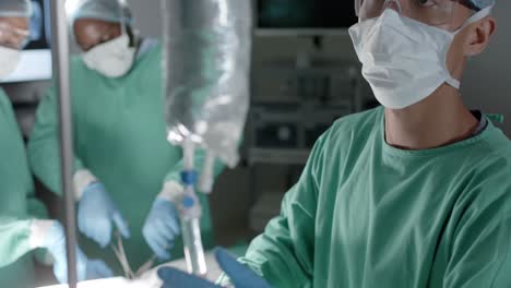 Diverse-surgeons-with-face-masks-during-surgery-in-operating-room-in-slow-motion