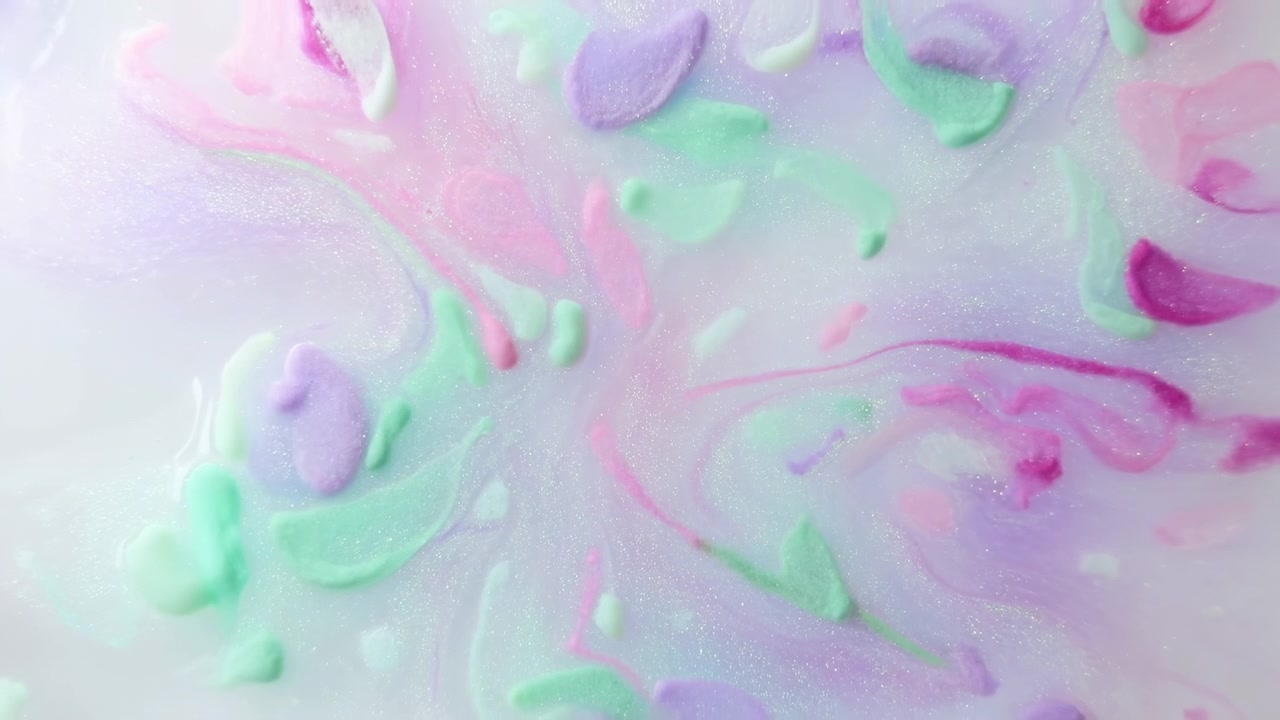 Pastel malingshvirvel på glat overflade, mintgrønne, lavendel og lyserøde pigmenter blandet i blank creme