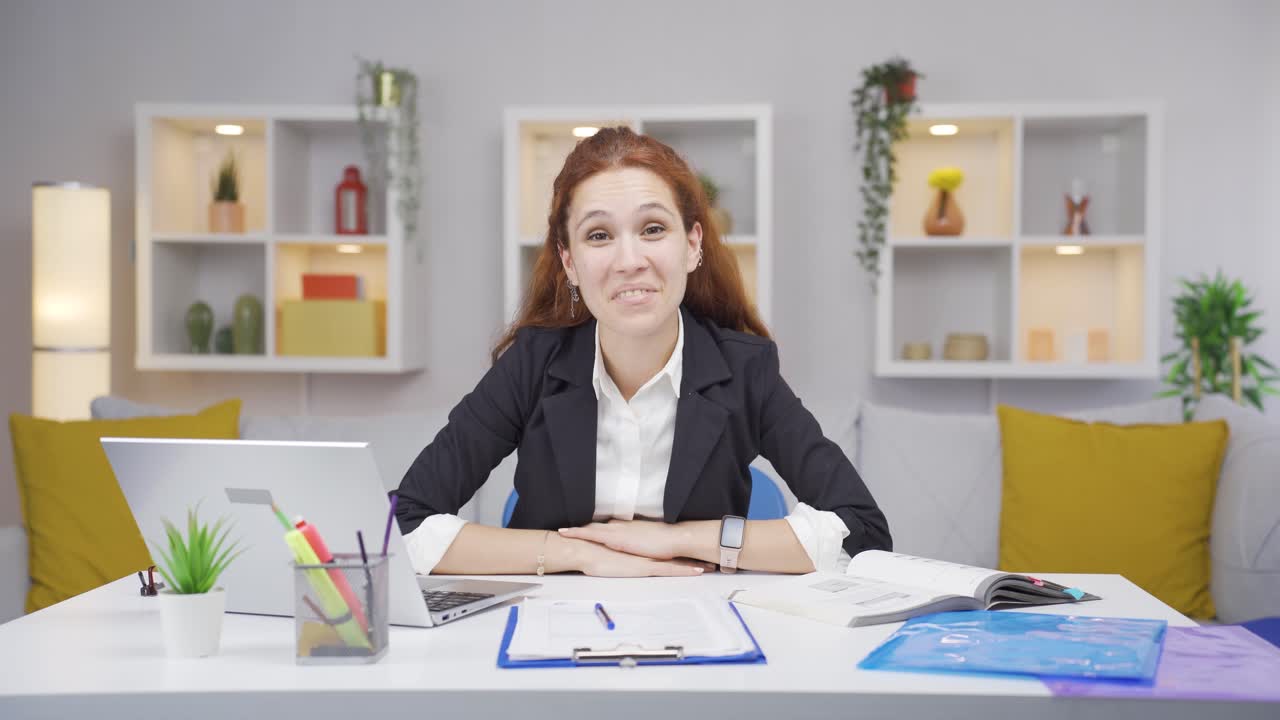 Thuiswerkende vrouw knikt naar de camera.