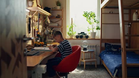 boy doing homework in his room