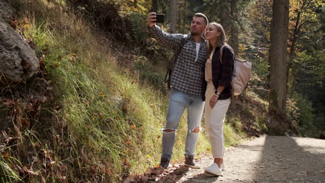 couple taking selfie in autumn forest