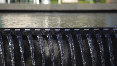 A-Waterfall-Spilling-Over-a-Wall-at-Whitby-Public-Library-Square,-Framed-with-a-Close-Up-Panning-Shot