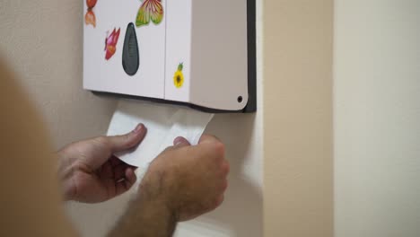 con un dispensador de toallas de papel montado en la pared