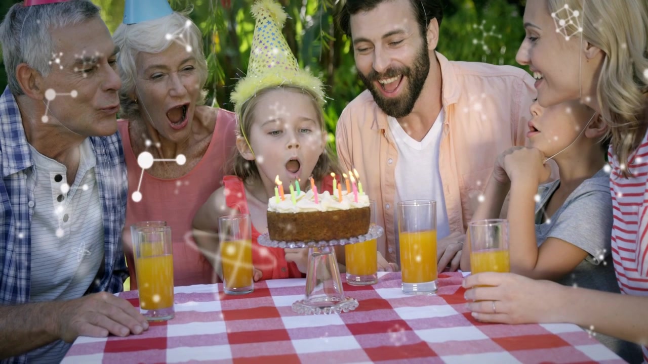 Barn puster lysene ud og ønsker sig noget i baghaven, mens familien smiler, og gnister cirkler om barnet.