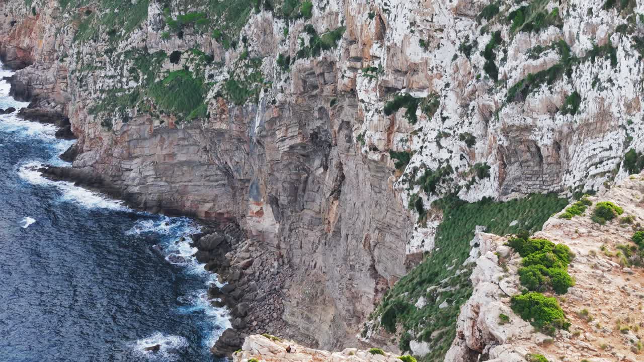 dron escénico, cámara hacia atrás, camino de la tapa al faro de formentor en altos acantilados rocosos en mallorca