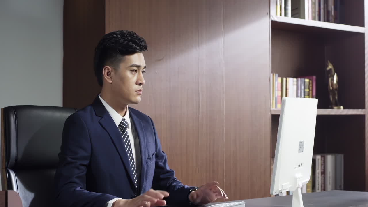 Portrait young confident businessman typing on laptop, making important business decisions in professional workspace. Concept of leadership, corporate strategy, success, professionalism