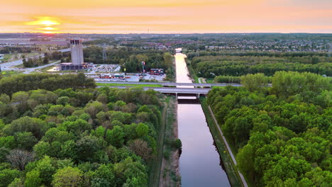 sunset over a lush green river landscape. a serene river flows through dense greenery as the sun sets, casting warm colors across the sky and water