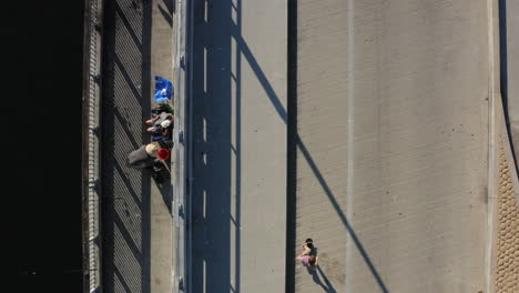 Young-skater-ride-and-do-tricks-on-coastline-of-Seal-Beach-in-Los-Angeles,-aerial-top-down-view