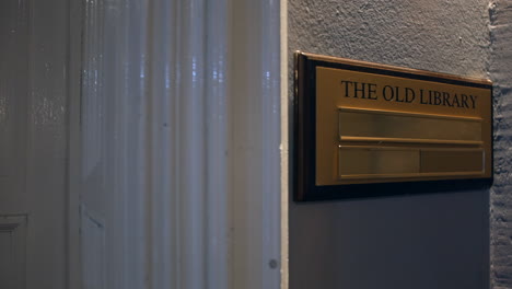 the old library sign in a manor house hotel outside a door